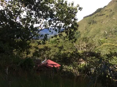 a red bench sitting in the middle of a hill at Illariy Tampu Ecoalbergue Oxapampa in Oxapampa