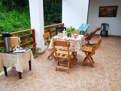 a patio with a table and chairs on a porch at Illariy Tampu Ecoalbergue Oxapampa in Oxapampa