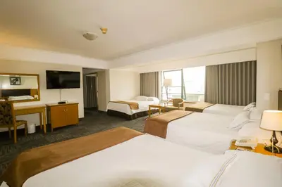 a hotel room with two beds and a television at Hotel Miramar in Lima