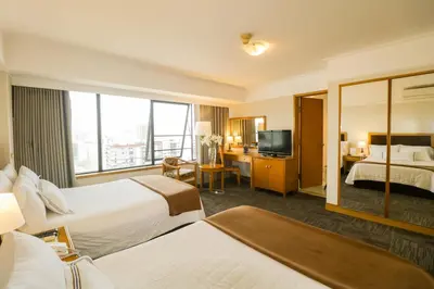 a hotel room with two beds and a television at Hotel Miramar in Lima