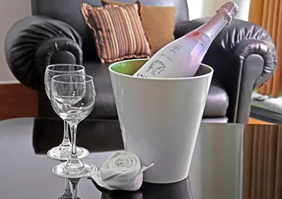 a bottle of wine in a bucket on a table with a glass at Inkari Suites Hotel in Lima