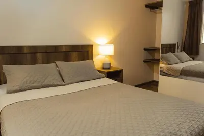 a bedroom with a bed and a lamp on a table at Montreal Hostal in Lima