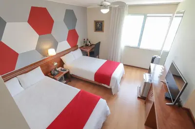 a hotel room with a bed and a television at Hotel Boutique Runcu Miraflores in Lima
