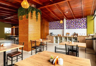 a restaurant with wooden tables and chairs and a kitchen at Miraflores Suites Centro in Lima