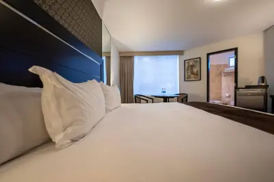 a bedroom with a large bed with white pillows at Jose Antonio Executive in Lima