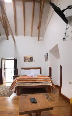 a bedroom with a bed and a wooden table at Casa Union Cusco in Cusco