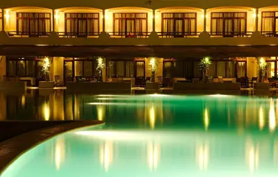 a hotel lobby with a swimming pool at night at La Hacienda Bahia Paracas in Paracas