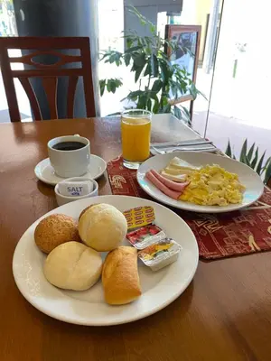 a table with two plates of breakfast foods and drinks at Faraona Grand Hotel in Lima