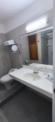a bathroom with a sink and a toilet and a mirror at Faraona Grand Hotel in Lima