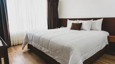 a hotel room with a large bed with white sheets at Faraona Grand Hotel in Lima