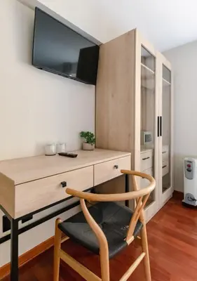 a room with a desk with a tv on the wall at Torre Dorada Cusco in Cusco