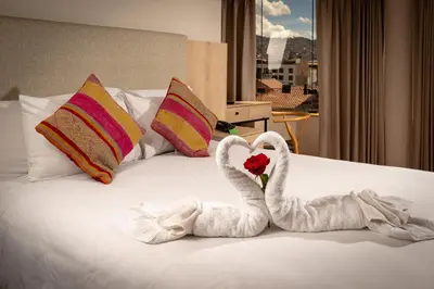 two swans made out of towels sitting on a bed at Torre Dorada Cusco in Cusco