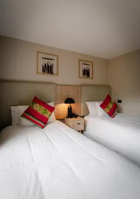 two white beds sitting next to each other in a room at Torre Dorada Cusco in Cusco