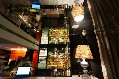 a bar with a man standing behind a counter at Roosevelt Hotel & Suites in Lima