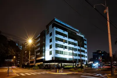 a lit up building on a city street at night at Roosevelt Hotel & Suites in Lima