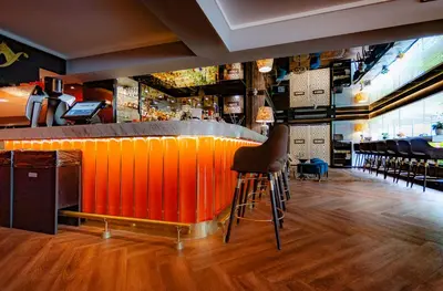 an orange bar with chairs in a restaurant at Roosevelt Hotel & Suites in Lima