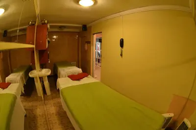 a small room with two beds and a sink at Nodo Cusco Santa Teresa in Cusco