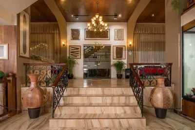 a lobby with a staircase with vases at Hotel Ruinas in Cusco