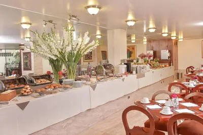 a buffet line in a restaurant with flowers and food at Hotel Ruinas in Cusco