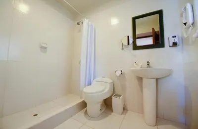 a white bathroom with a toilet and a sink at Hotel Boutique Gold Garden in Cusco