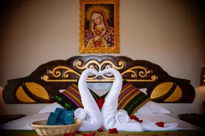 two swans made to look like they are kissing on a bed at Hotel Boutique Gold Garden in Cusco