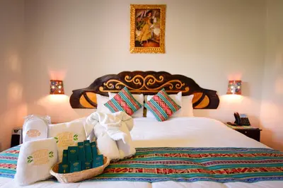 a bedroom with a large bed with towels and a basket on it at Hotel Boutique Gold Garden in Cusco