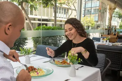 a man and a woman sitting at a table eating food at Casa Andina Premium Miraflores in Lima