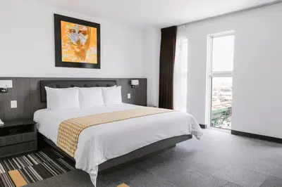 a bedroom with a large bed and a large window at Wyndham Costa del Sol Lima Airport in Lima