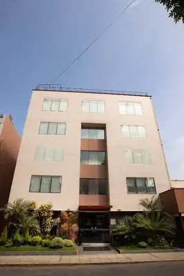 a tall white building with trees in front of it at Centro by Casa Andina Miraflores in Lima