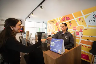 a man and a woman shaking hands at a cash register at Centro by Casa Andina Miraflores in Lima