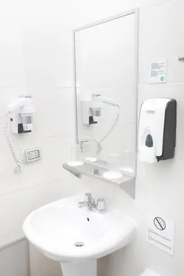 a white bathroom with a sink and a mirror at Casa Andina Standard Cusco Catedral in Cusco