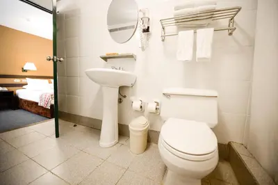 a bathroom with a toilet and a sink and a mirror at Hotel Raymi in Cusco