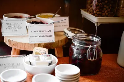 a table with jars of jam and bowls of food at Hotel Raymi in Cusco