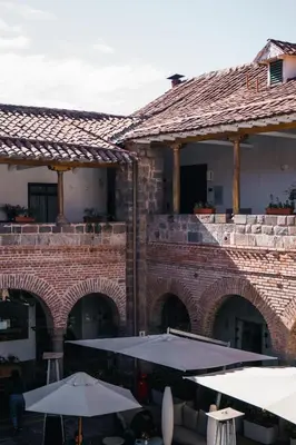 a large brick building with tables and umbrellas at Casa Andina Premium Cusco in Cusco