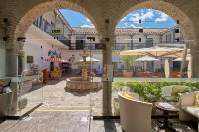 an outdoor patio with chairs and tables and umbrellas at Casa Andina Premium Cusco in Cusco