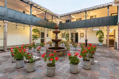 a courtyard with a fountain with flowers in pots at Casa Andina Premium Cusco in Cusco