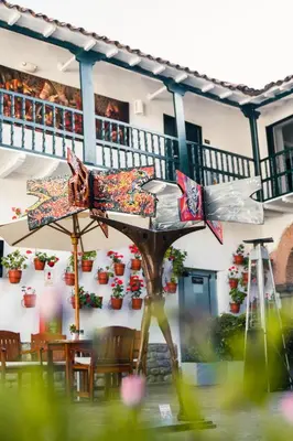 a person standing in front of a building with a table at Casa Andina Premium Cusco in Cusco