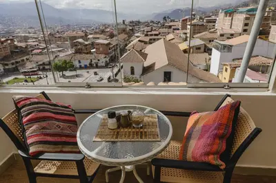 a table and chairs with a view of a city at Cozy Room Cusco in Cusco
