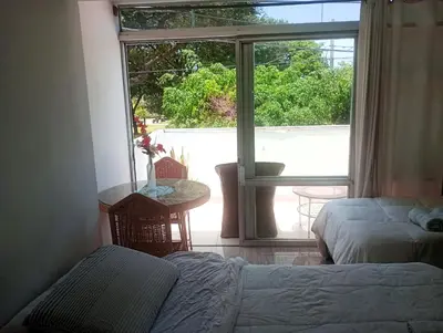 a bedroom with a bed and a table and a window at Monterrico Suites Hotel in Lima
