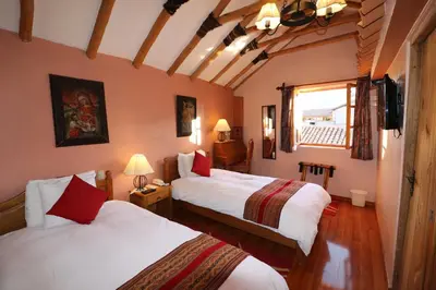a hotel room with two beds and a window at Hotel & Mirador Los Apus in Cusco
