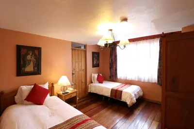 a hotel room with two beds and a window at Hotel & Mirador Los Apus in Cusco