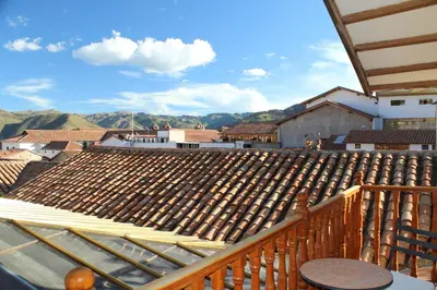 a view of the roof of a building with mountains in the background at Hotel & Mirador Los Apus in Cusco