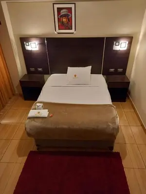 a bedroom with a large bed with two night stands at Hotel Mantas Cusco in Cusco