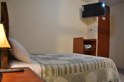 a bedroom with a bed and a flat screen tv at Rosenverg B&B Tours in Lima