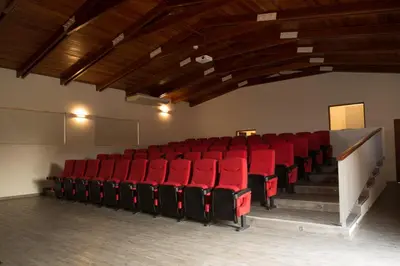 an empty auditorium with red chairs in a room at Decameron El Pueblo in Lima