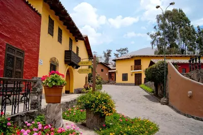 a courtyard of a building with flowers in a yard at Decameron El Pueblo in Lima