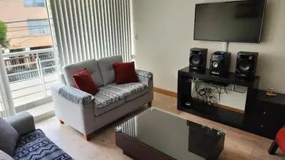 a living room with a couch and a flat screen tv at Miraflores Modern Baja Balta in Lima