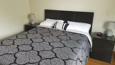 a bedroom with a bed with a black and white comforter at Miraflores Modern Baja Balta in Lima