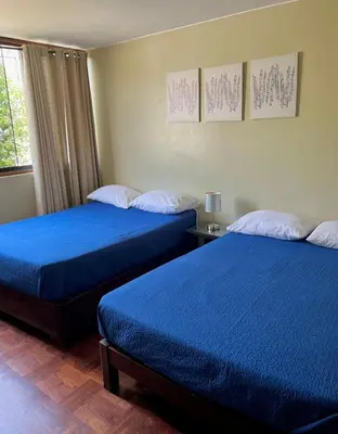 two beds in a room with blue sheets at Lima Mini Aparts Monterrico - Cerca Embajada EEUU in Lima
