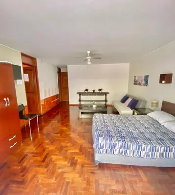 a bedroom with a bed and a couch at Lima Mini Aparts Monterrico - Cerca Embajada EEUU in Lima